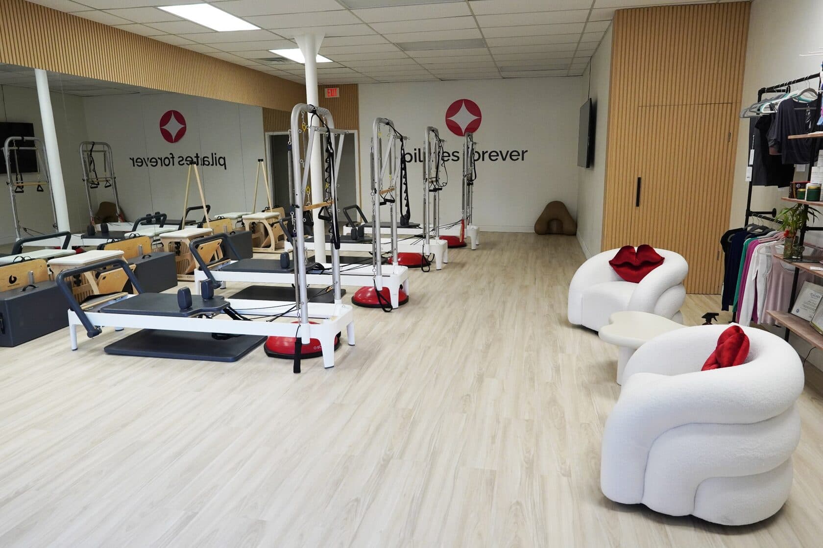 Pilates Forever studio with reformers and white lounge chairs
